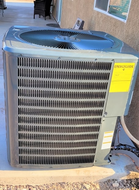 air-conditioner-new-air-conditioner-unit-installe-2022-11-08-06-09-04-utc-1-min Outdoor air conditioner with yellow sticker on heat pump.
