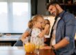 A man and a child drinking orange juice.
