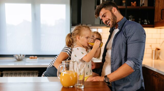 A man and a child drinking orange juice. A man and a child drinking orange juice.