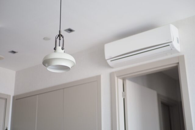 An air conditioner hanging from the ceiling in a room. An air conditioner hanging from the ceiling in a room.