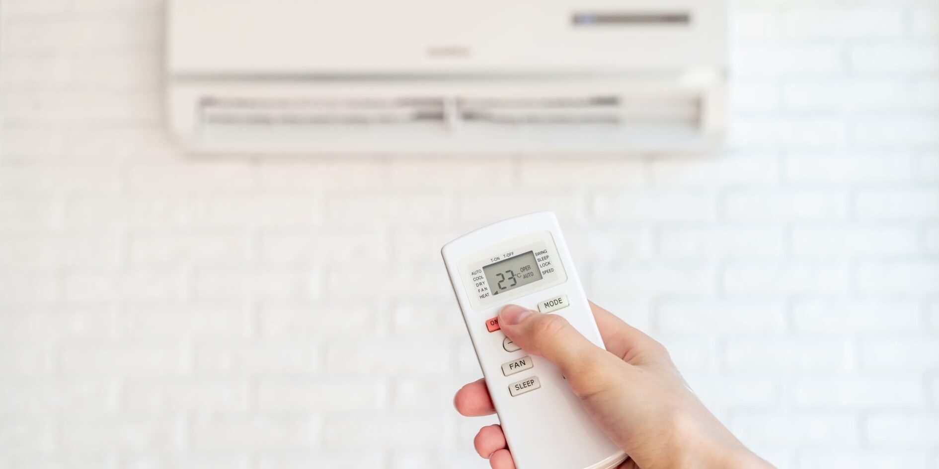 A hand holding a remote control.