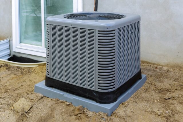 An air conditioner in front of a house. An air conditioner in front of a house.