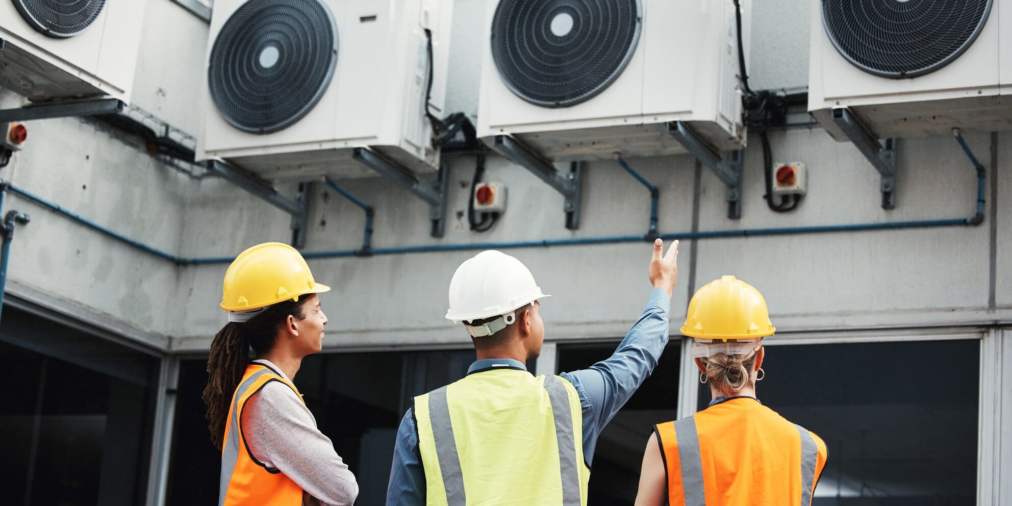 A group of people wearing hard hats and vests.