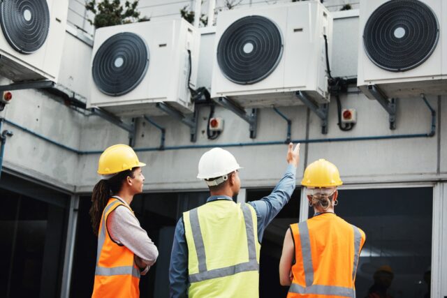 A group of people wearing hard hats and vests. A group of people wearing hard hats and vests.