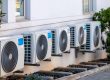 Row of air conditioning units installed outside a building.
