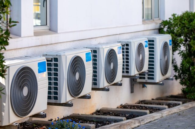 Row of air conditioning units installed outside a building. Row of air conditioning units installed outside a building.