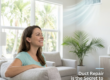 A woman in a bright, modern Florida living room sneezing into a tissue while looking up toward a ceiling air conditioning vent. The scene captures the discomfort of indoor allergens, with soft sunlight streaming through a window, highlighting the need for air duct repair to prevent mold and dust circulation.