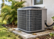 An outdoor air conditioning unit needing air conditioner cleaning, installed on a concrete pad next to a house.