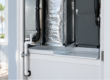 An HVAC air handler unit inside a closet with water dripping from the unit into a white overflow drain pan. How to clean AC drain lines and inspect an air handler drain pan in a Southwest Florida home